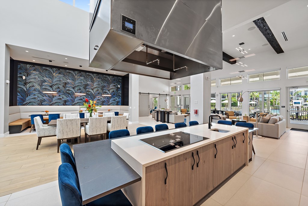 A modern kitchen with a long island and blue chairs. at Mira at Palmer Ranch, Sarasota, FL, 34238