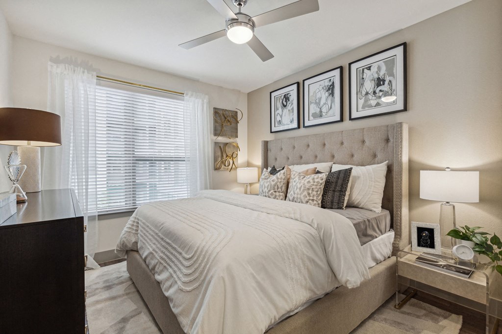 Model apartment bedroom with large window and ceiling fan at LynnCora, Grand Prairie, Texas