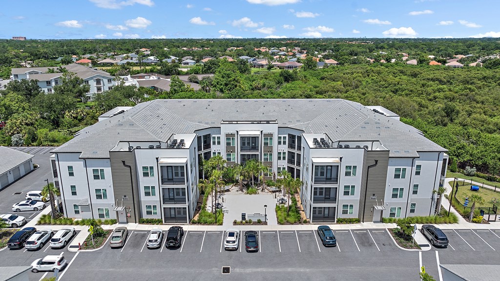 A large building with a parking lot in front of it. at Mira at Palmer Ranch, Sarasota, FL, 34238