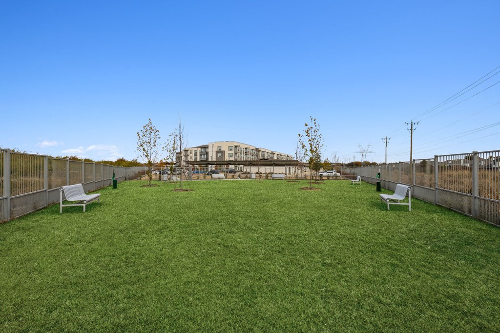 a yard with benches and a large building in the background at LynnCora, Grand Prairie, TX, 75052