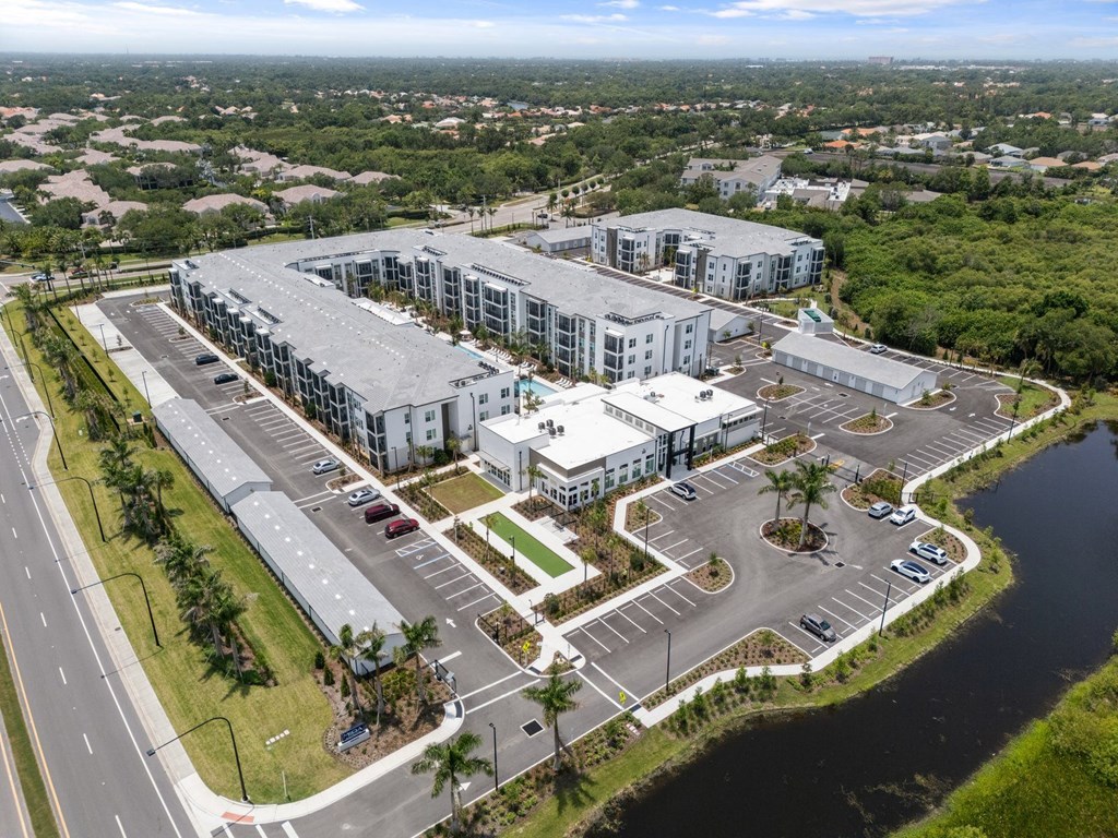 an aerial view of apartment buildings next to a body of water