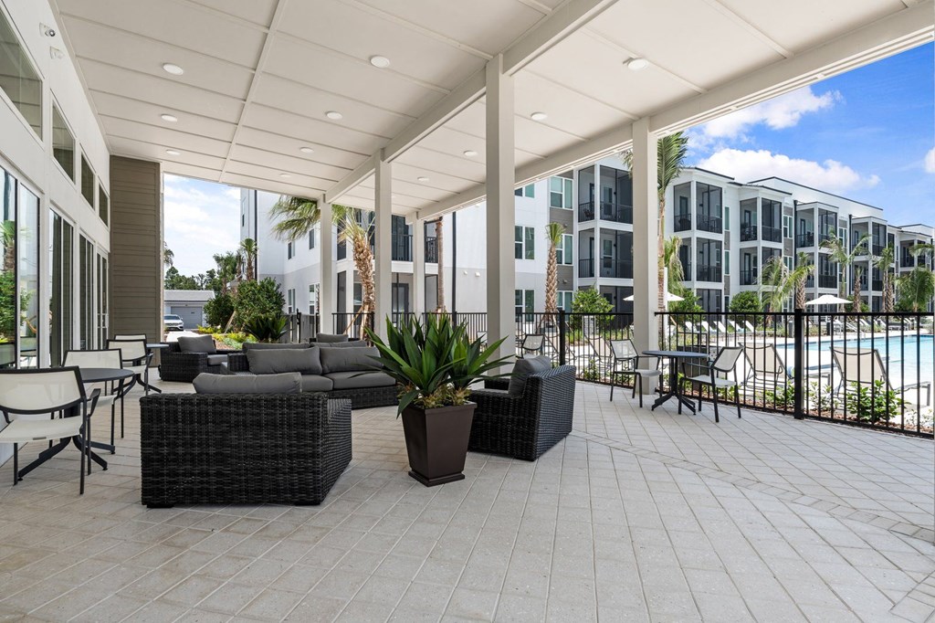 a large patio with furniture and a pool in front of an apartment building