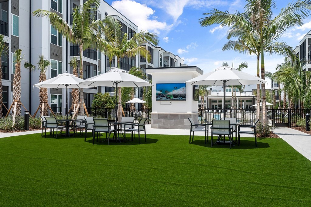 a patio with tables and umbrellas in front of a building