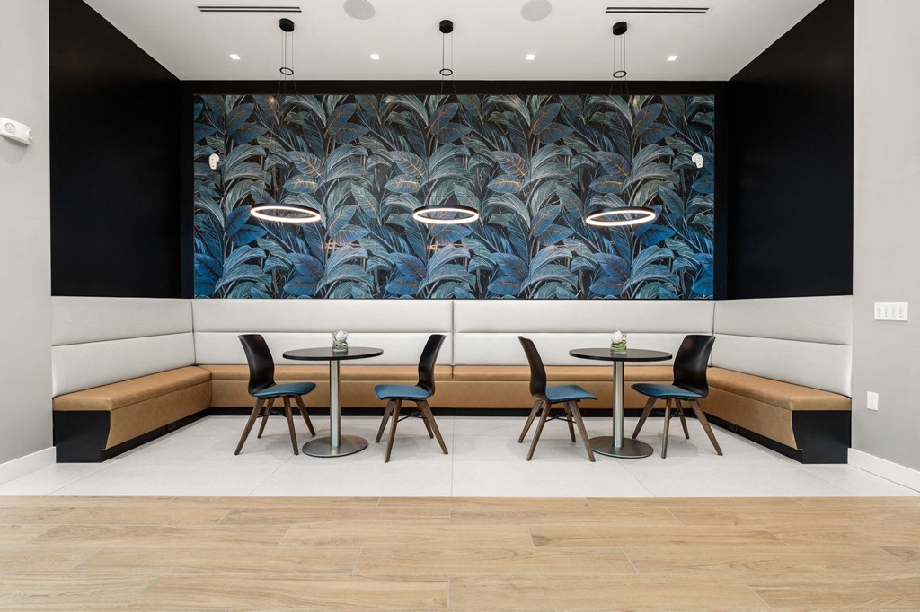 resident lounge with tables and chairs and a large mural on the wall