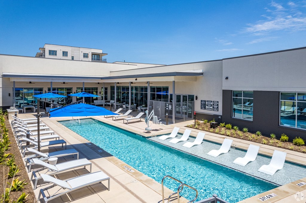 Ironcrest view of swimming pool with chaise lounge chairs and umbrellas