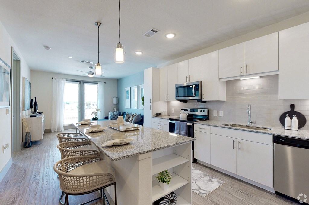Ironcrest model kitchen with white cabinets and a large island with granite countertops