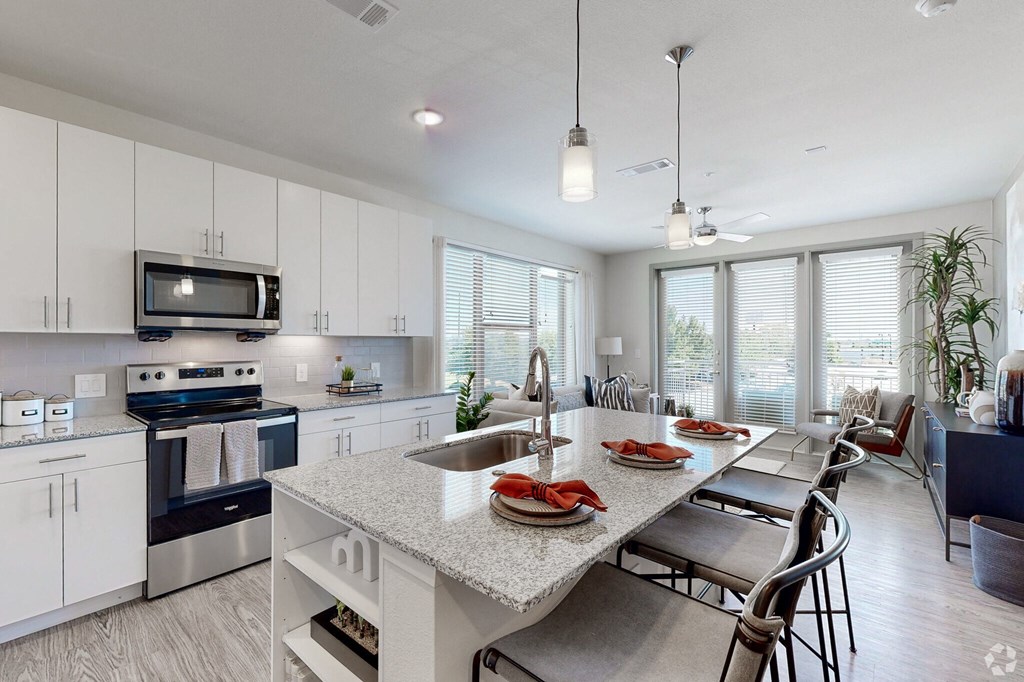 Ironcrest model kitchen with white cabinets and a large island with a granite countertop and stainless steel appliances