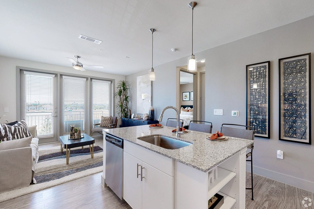 Ironcrest model apartment kitchen with an island and a living room in the background