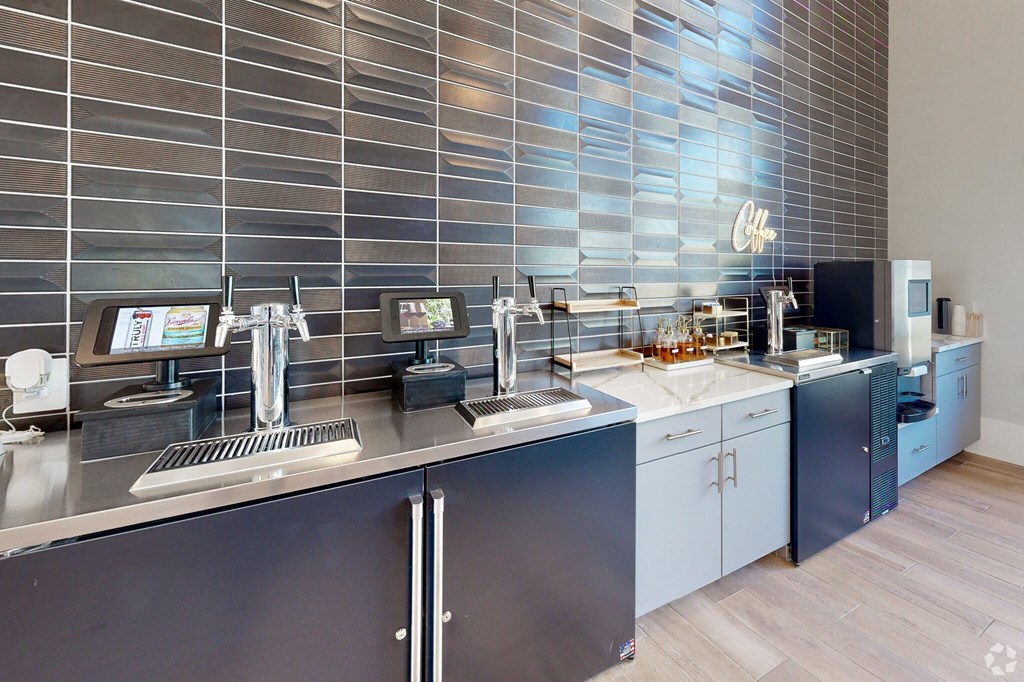 a kitchen with blue cabinets and stainless steel countertops in coffee bar area