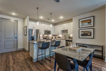 a kitchen and dining area with large island and stainless steel appliances at LynnCora in Grand Prairie, TX