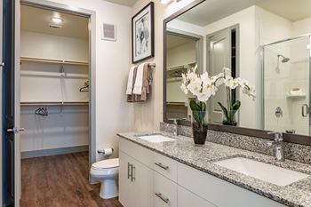 a bathroom with double sink, granite countertops and a large mirror at LynnCora in Grand Prairie, TX