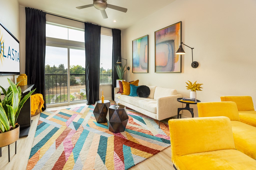 Solasta apartment living room with ceiling fan and large windows