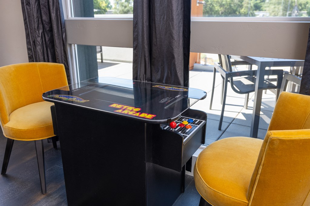a game table in a room with yellow chairs