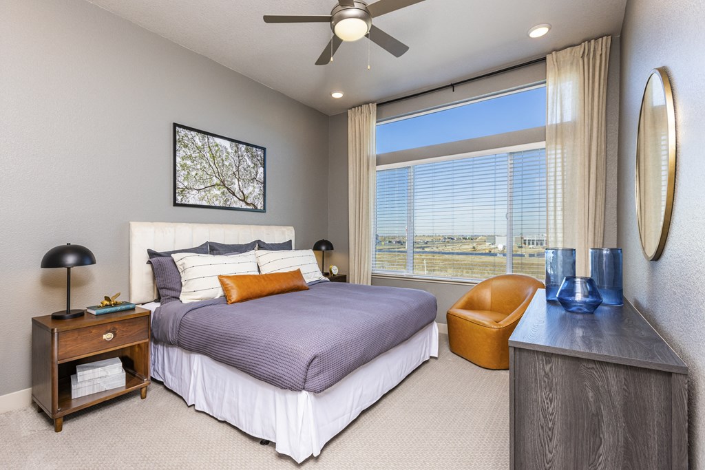 apartment bedroom has a large window and lighted ceiling fan apartment bedroom has a large window and lighted ceiling fan at Zeta Luxury Apartments in Sacramento, CA