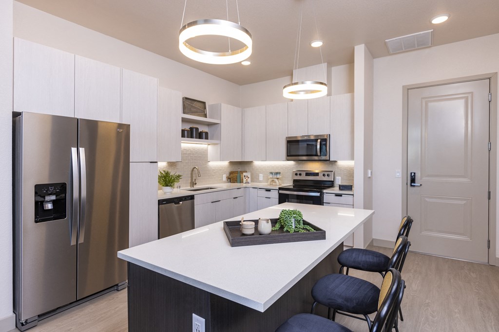 a kitchen with stainless steel appliances and quartz counter tops