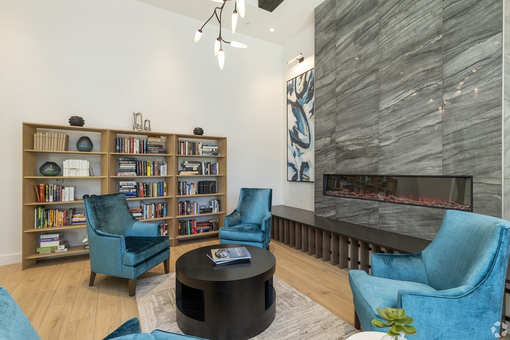 A living room with a fireplace and a bookshelf. at Mira at Palmer Ranch, Florida, 34238