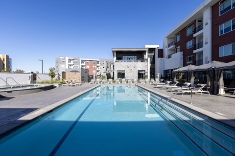 A large swimming pool with Amara Apartment buildings in the background