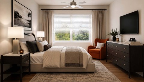 Modern bedroom with neutral bedding and orange chair at Velo Luxury Apartments, Sarasota, FL 34233