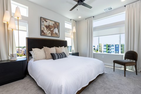 A bedroom with a large bed and a ceiling fan.