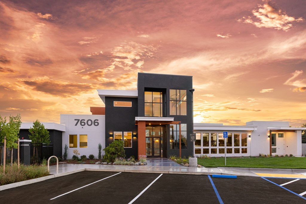 Solasta leasing office and clubhouse exterior with sunset in the background