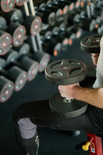 a man lifting a dumbbell in a gym at Zeta Luxury Apartments, Sacramento, CA