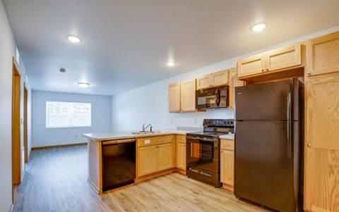 A kitchen with wooden cabinets and appliances.