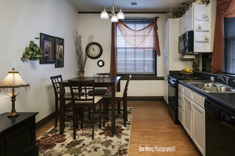 A kitchen with a table and chairs in the middle.