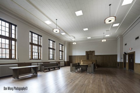 A large, empty room with wooden floors and white walls.