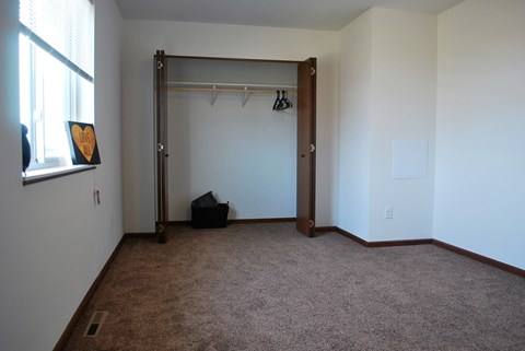 A room with a brown carpet and a white wall.
