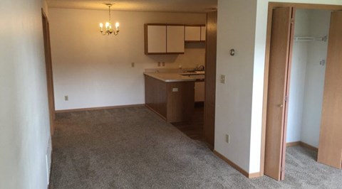 A room with a kitchenette and a chandelier.