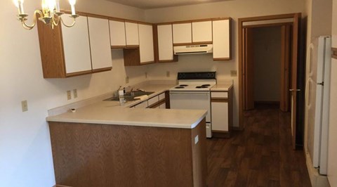 A kitchen with white cabinets and a wooden island.