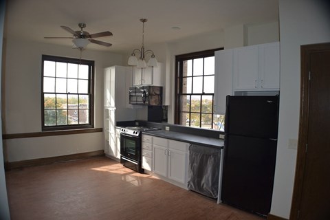 A kitchen with black appliances and white cabinets.