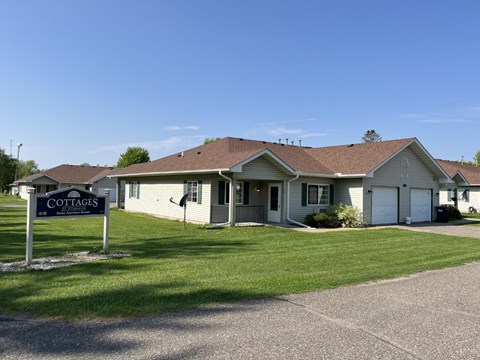 A sign in front of a building that says "Cottages".