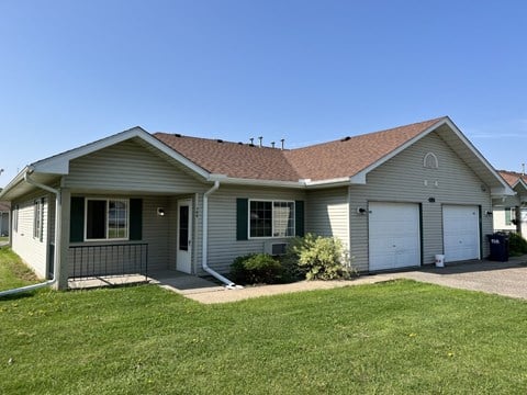 A house with a grey roof and green shutters.