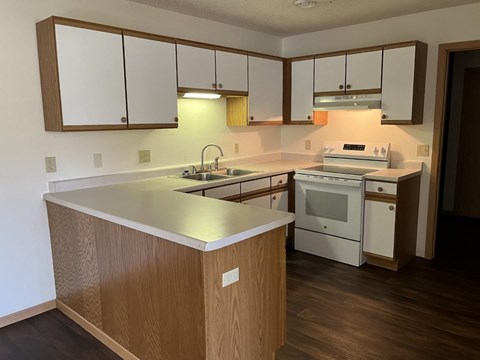 A kitchen with wooden cabinets and a white counter.