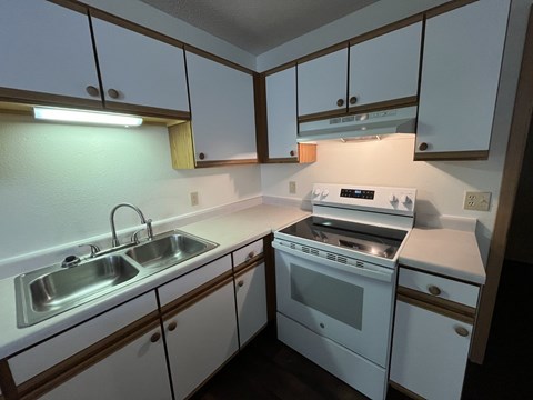 A small kitchen with a white oven and sink.