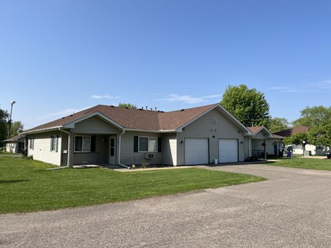 A house with a grey roof and a driveway in front.