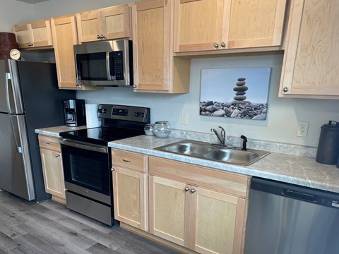 A kitchen with wooden cabinets and a fridge.
