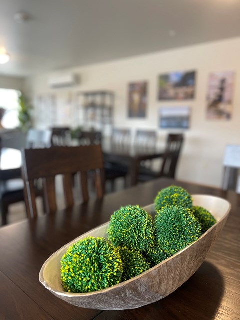 A bowl of green and yellow food sits on a wooden table.