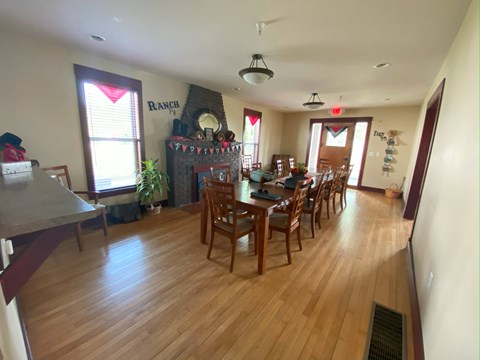 A dining room with a wooden table and chairs.