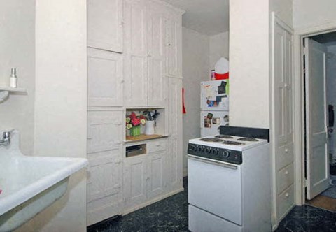 a white kitchen with a stove and a refrigerator