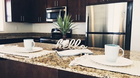 A kitchen counter with a sign that says "hello" and two cups on it.