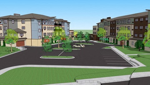 A street view of a residential area with apartment buildings and a roundabout.