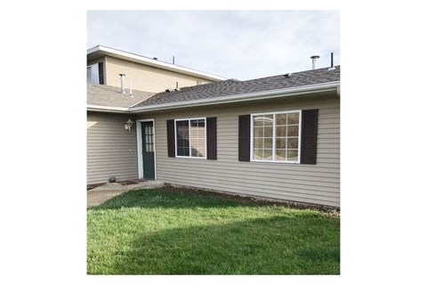 A house with a green door and black shutters.