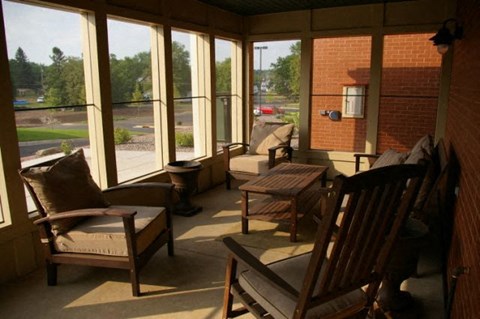A sunny day in a room with a view of a parking lot through the windows.