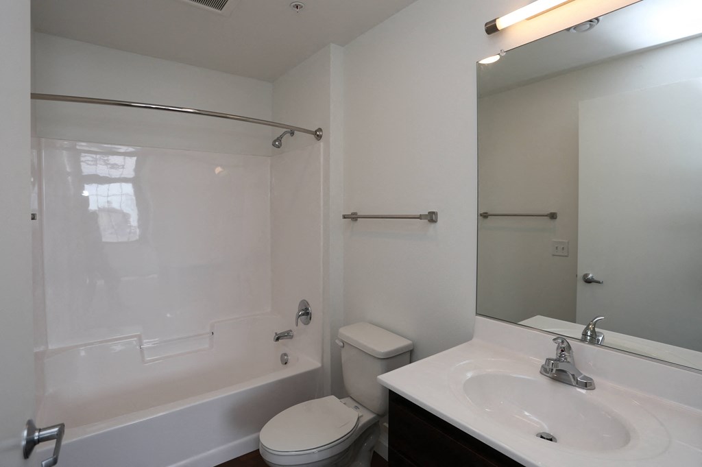 A white toilet sits next to a bathtub in a bathroom.