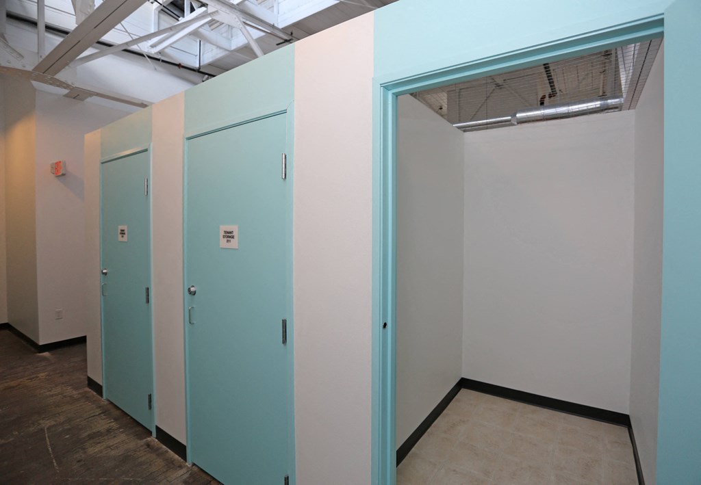 A row of three bathrooms with blue doors.