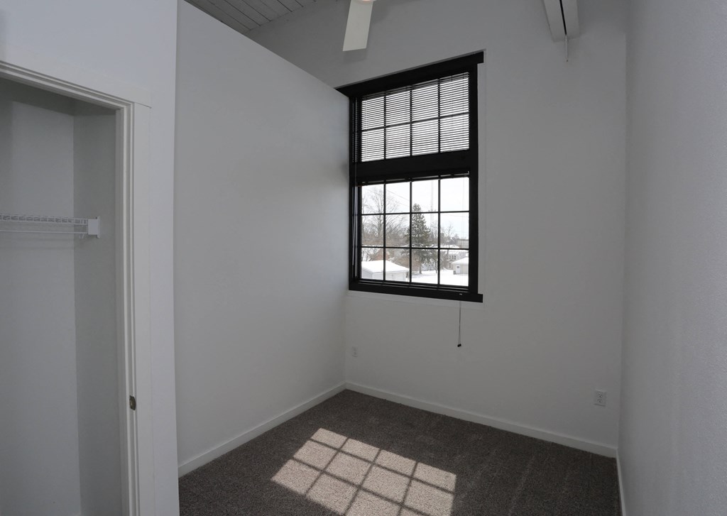 A room with a window and a carpet on the floor.