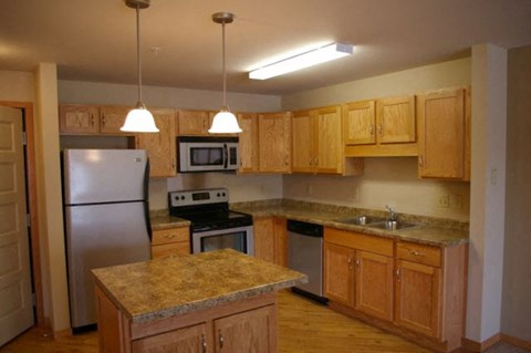 A kitchen with wooden cabinets and granite countertops.