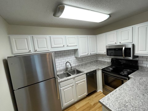 a kitchen with stainless steel appliances and white cabinets